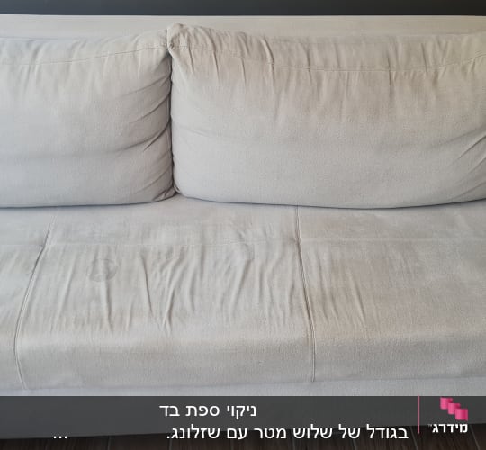 ספה אפורה עם כתמים על הרצפה